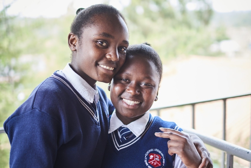 Två elever från Kenswed i Kenya håller om varandra.
